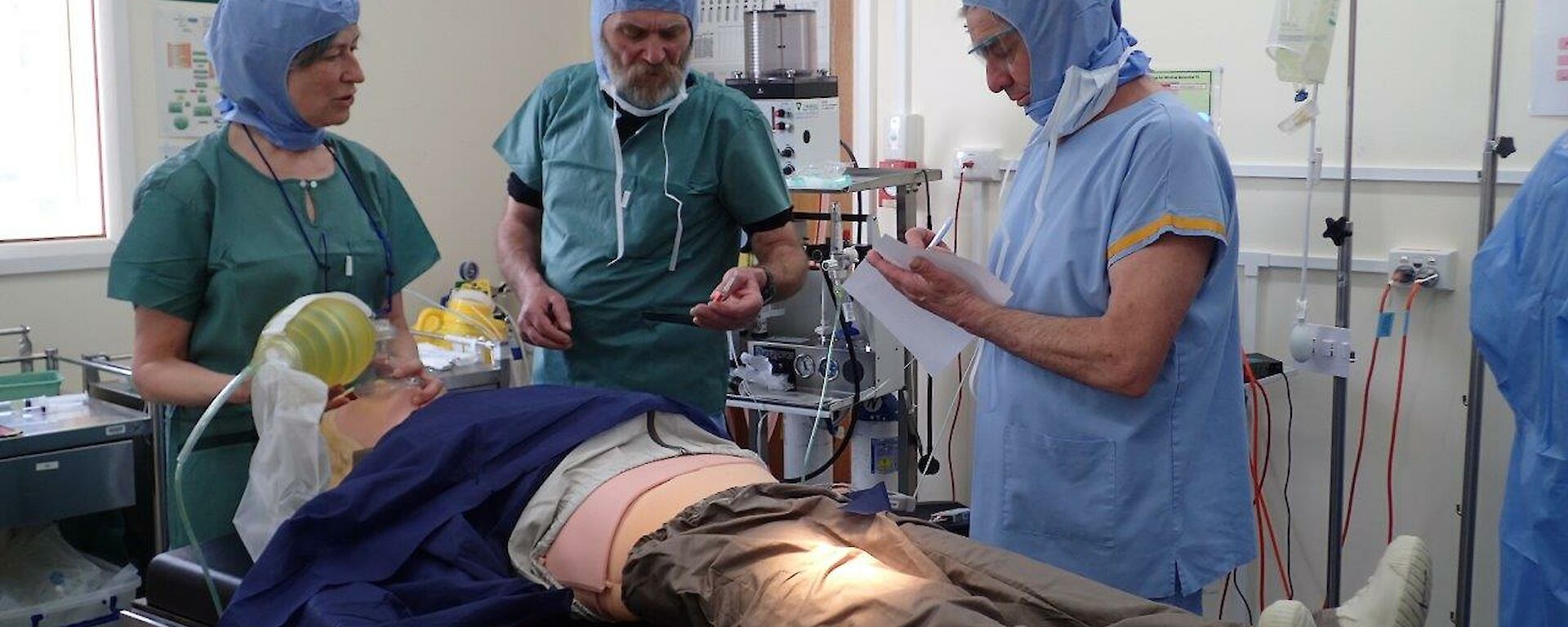 A woman talks to two men over a hospital guerney