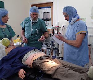 A woman talks to two men over a hospital guerney