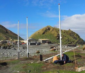 Two men erecting a painted flagpole in the sunshine