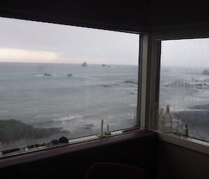 A view out the corner windows of the hut from the inside looking out over the water