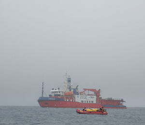 The inflatable rubber boat carrying cargo on the way back to shore