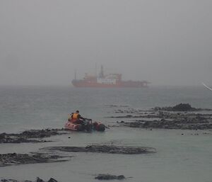 An ifatable rubber boat heading out to the ship