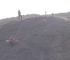 The stretcher being lowered over the cliff