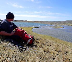 A man sits in the sun at the lakes on the island