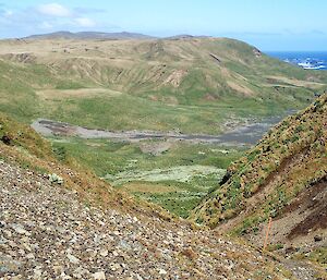 A view of hills and Bauer Bay hut visible in the distance