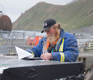A man checking his paperwork sitting down near the cove