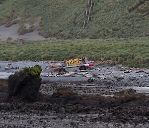 New expeditioners and visitors on a LARC arrive on shore