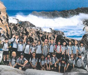 A school class photo in front of a picture wall