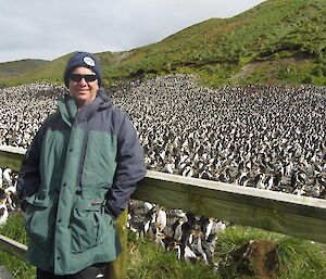 A man stands in front of the Royal penguin colony