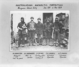 A group of men in front of a hut