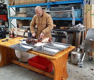 A man carving meat on a table