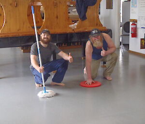 2 men cleaning a floor