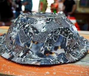 A paper mache bowl made out of penguin photos