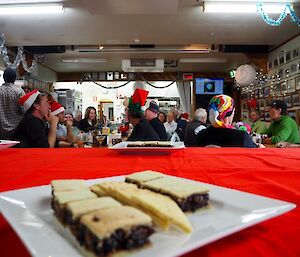 A plate of slice and shortbread with people dining in the background