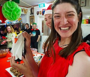 A woman holds up her penguin stubby holder