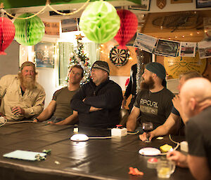 A group of people sitting around a table playing a quiz