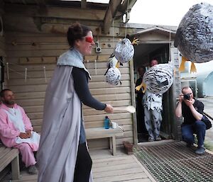 A woman in princess costume playing piñata