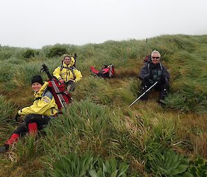 Three people in the field, taking a break in the vegetation