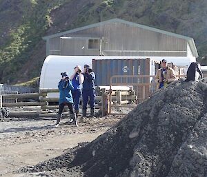 A chinstrap penguin visiting the isthmus being photographed by many of the expeditioners at the station