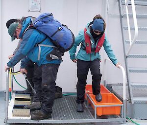 2 people cleaning boots at the biosecurity checkpoint after boarding the Prof. Khromov