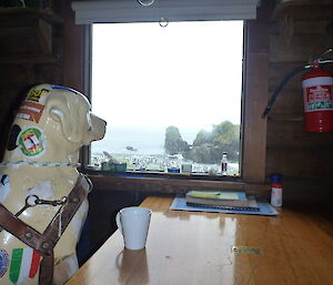 Fibreglass dog inside the hut looking out the window