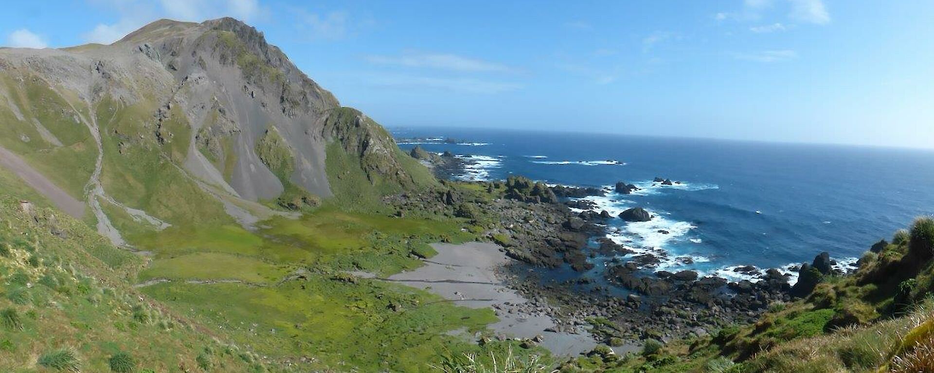 Mt Waite and Sellick Bay on the west coast of Macquarie Island. The bay has been carved from a small fault line that lies on the northern side of mountain. Over time, the gravel now observed on the scree slopes and gravelly sandy beaches has been stripped away. The massive basalt lava outcrop of Mt. Waite rises over 400m from the bay below.
