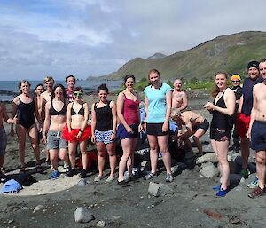 A group of people on the beach ready to go swimming