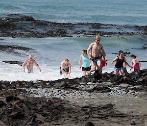 People exiting the surf back onto the beach after the swim.