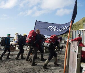 A group of people walk over the finish line into station.