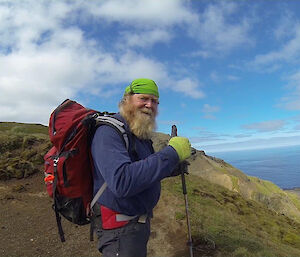 A man gives a thumbs-up signal at top of the hill before a steep desent