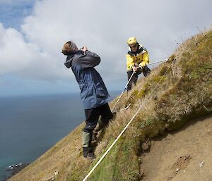two people photographing a steep plot.