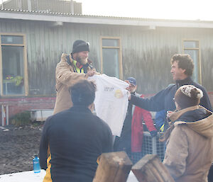 A man is presented a tee shirt