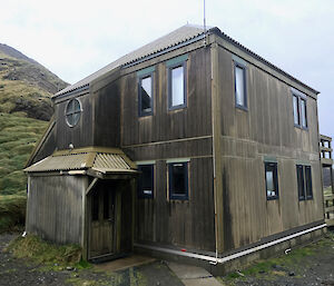 A photo of Cumpstons Cottage, a wooden two story hut.