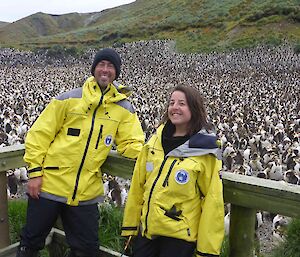 Andrea with Tasmanian Parks and Wildlife Service colleague Matt at Sandy Bay standing with thousands of penguins behind them- Macquarie Island