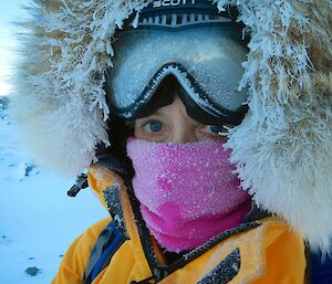 A woman dressed in all of the winter clothing looking frosty, taken during her time at Davis station.