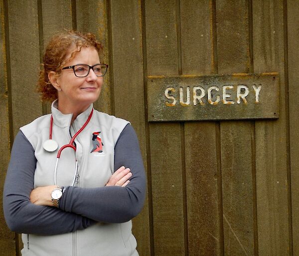 A photo of a woman who is the doctor on Macquarie Island outside her surgery