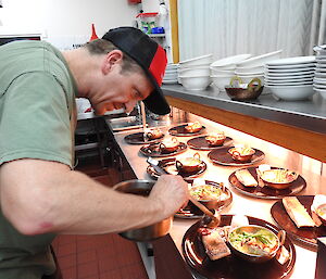 Chef Nick Baker putting food on the plates for another extraordinary Saturday night dinner — Macquarie Island