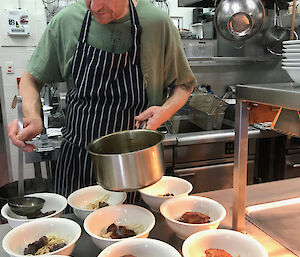 Chef Nick Baker preparing another amazing meal with many bowls of food on a bench.