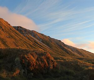 Th sun rising over Waterfall Bay with clear skies in the background.