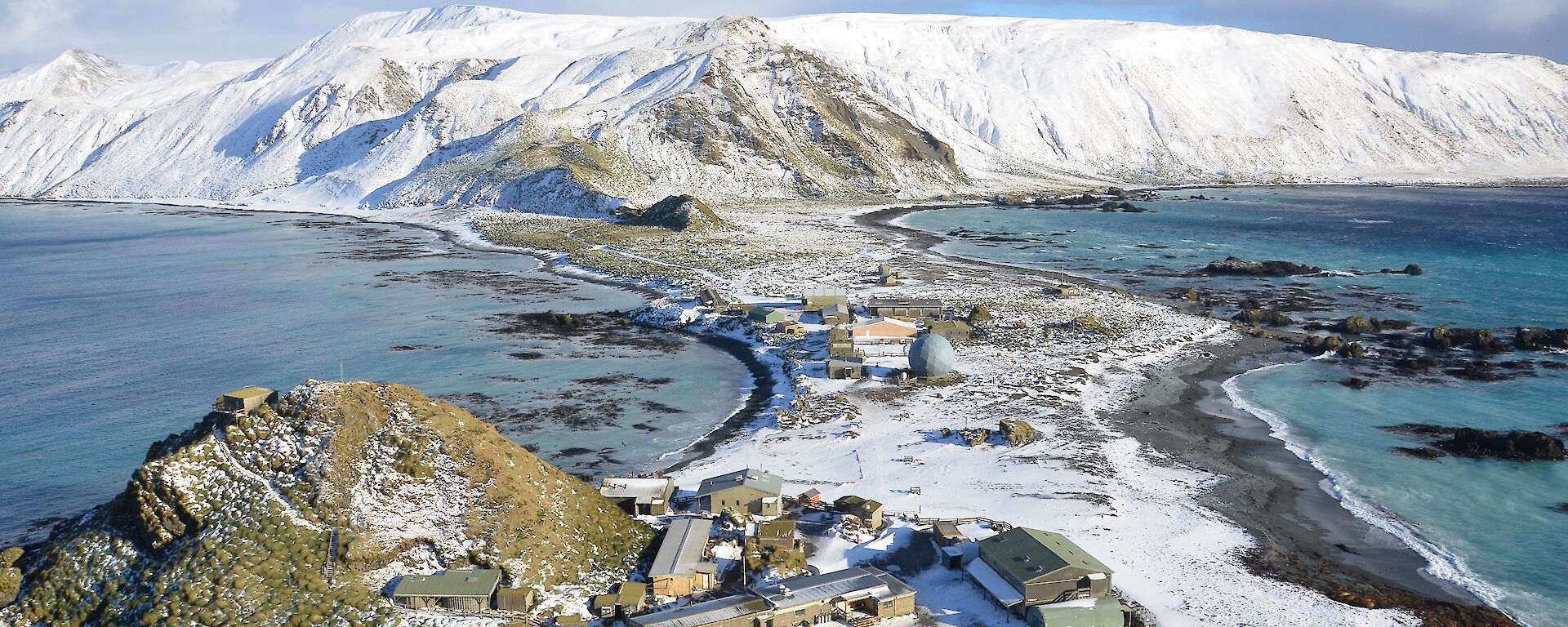 A view of the station from another hill all covered in snow.