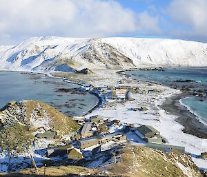 A view of the station from another hill all covered in snow.