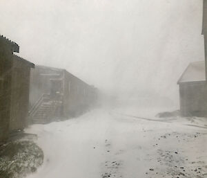 A small blizzard with the buildings just visible through the snow.