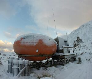A round field hut under snow.