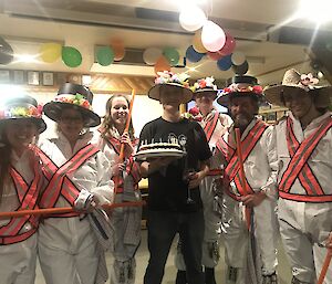 Chef Nick surrounded by expeditioners in Morris dancing costumes.