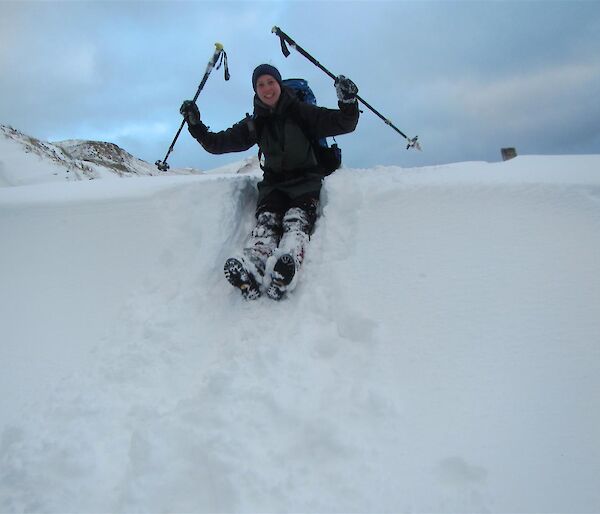 Albatross researcher Emily Mowat sitting on the edge of a big snow dune.