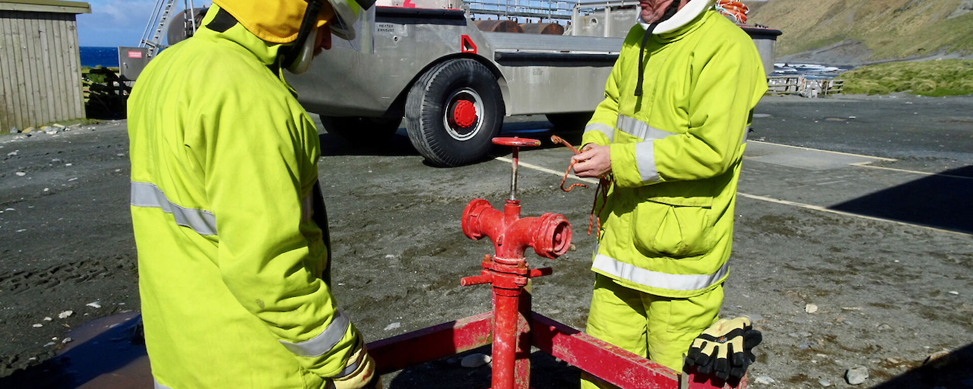 Two expeditioners standing outside in their fire fighting gear.