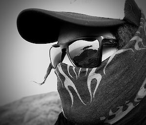 A closeup of a man wearing a mask and sunglasses.