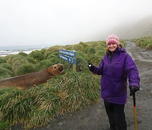 EA woman standing near a sign with a seal near it.