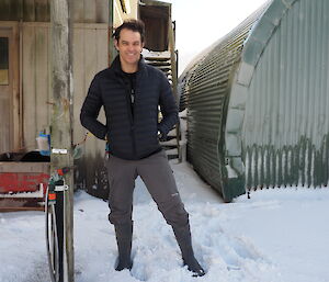 A man standing outside of a building in the snow.