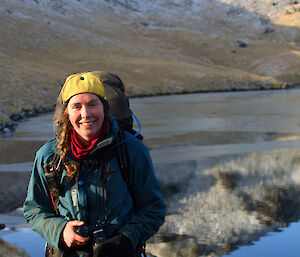 A woman standing with snow covered mountains around her.